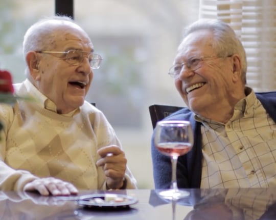 The Arbor Company senior living residents chatting and drinking wine