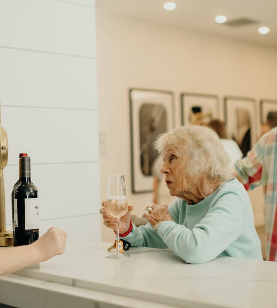 The Lakeside at Amelia Island senior living resident sipping glass of wine